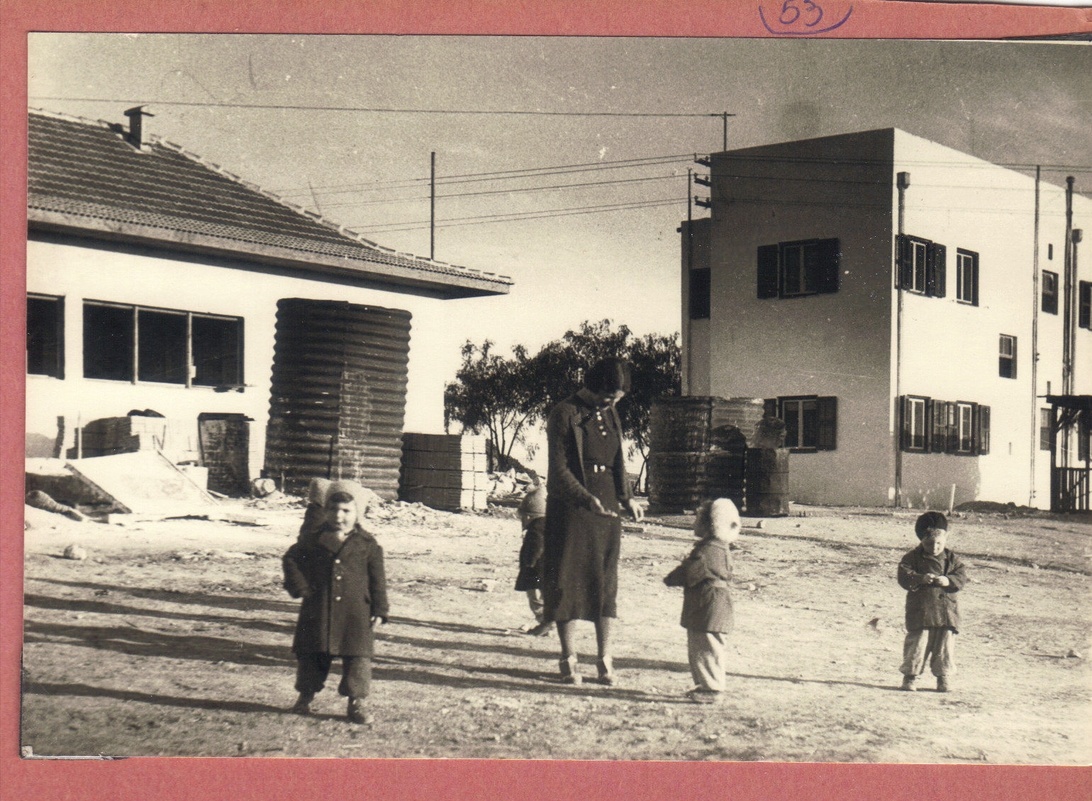 Svartvitt vintagefotografi som visar barn och vuxna i robusta kläder, vilket illustrerar en tid då hållbarhet var en självklarhet.